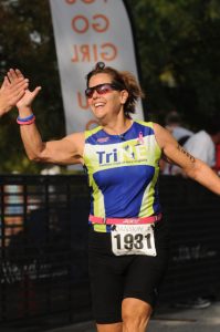 Dr. Marie Donabella getting a high five at the finish line of a triathlon.